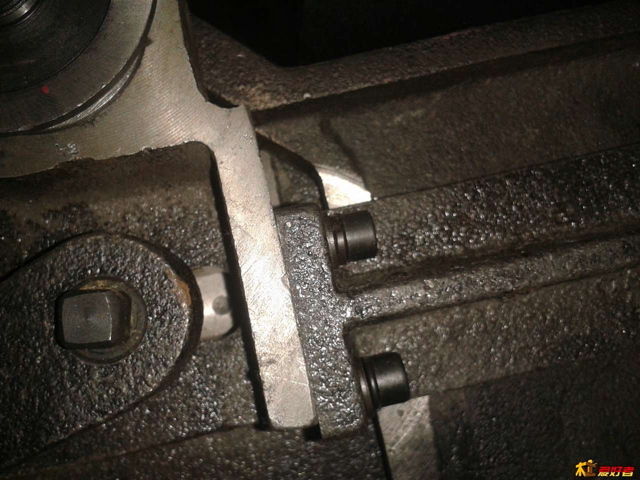 从台面下看到锯片轴旁两个螺丝，是用来调节分料器与锯片水平的，松动后轻轻用锤子敲击调整